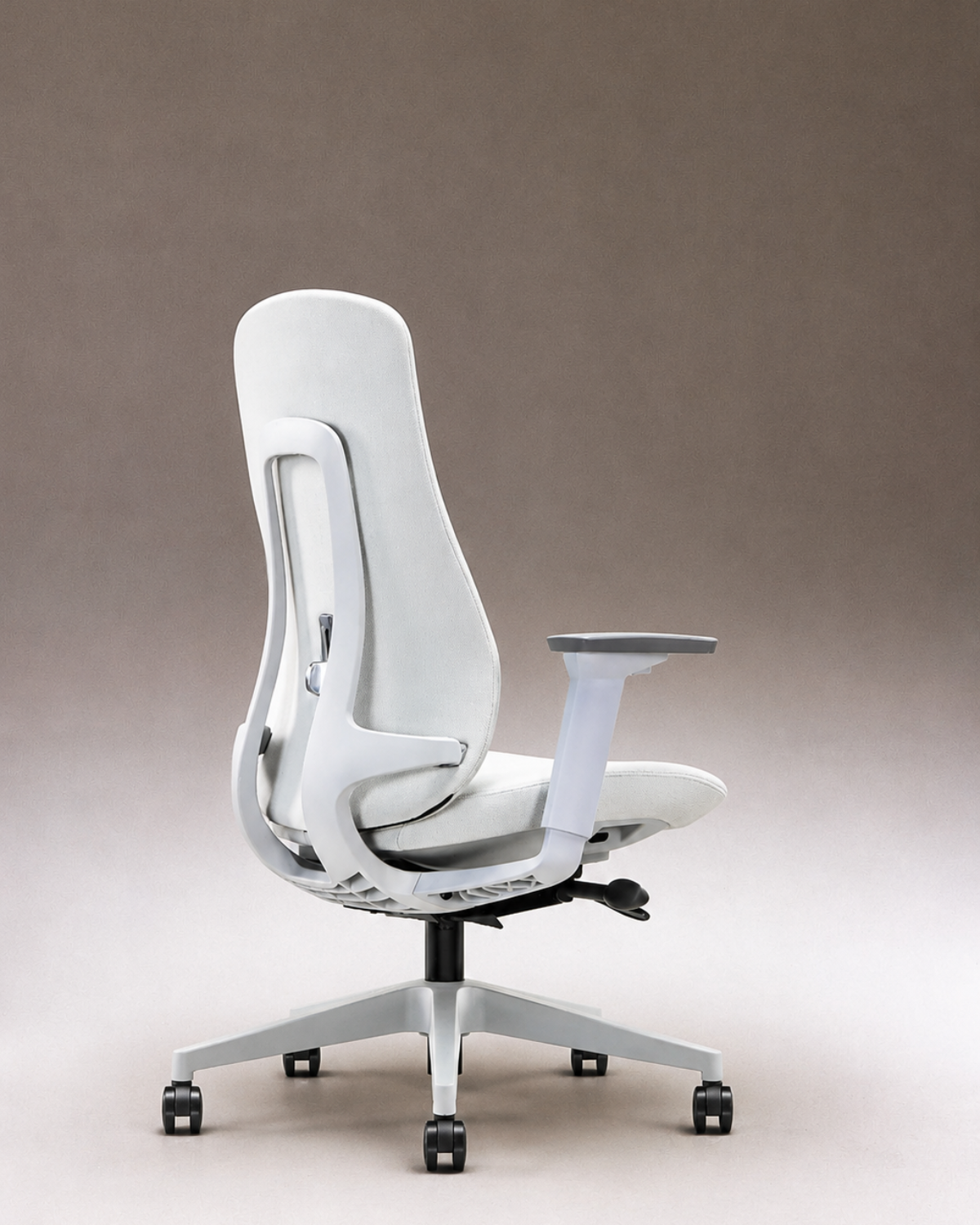 A modern ergonomic office chair with a white upholstered back and seat, a gray armrest, and a silver five-star wheeled base, shown against a neutral studio backdrop.