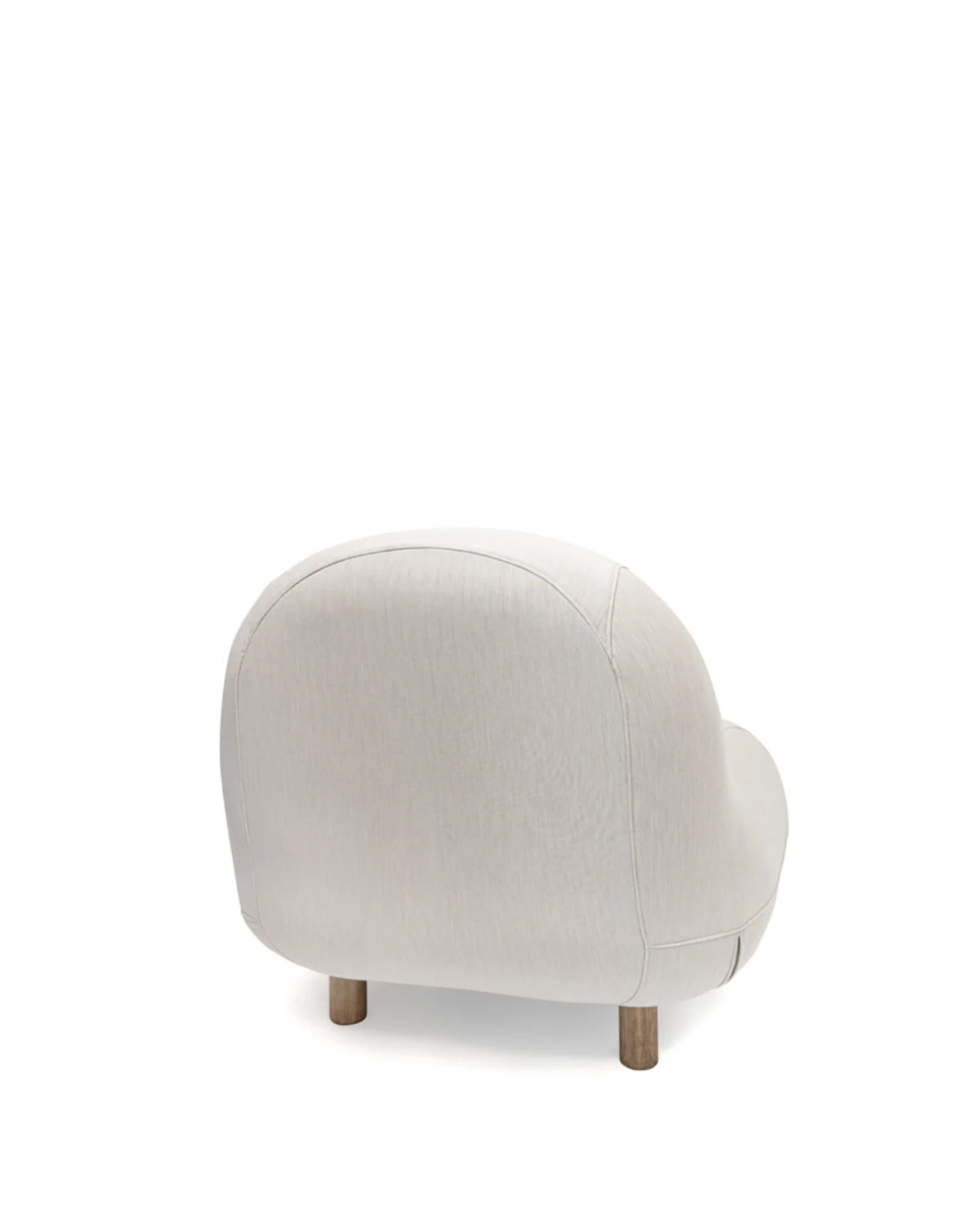 A modern rounded armchair upholstered in a light beige textured fabric, supported by four short wooden legs, shown from a three-quarters angle against a solid white background.