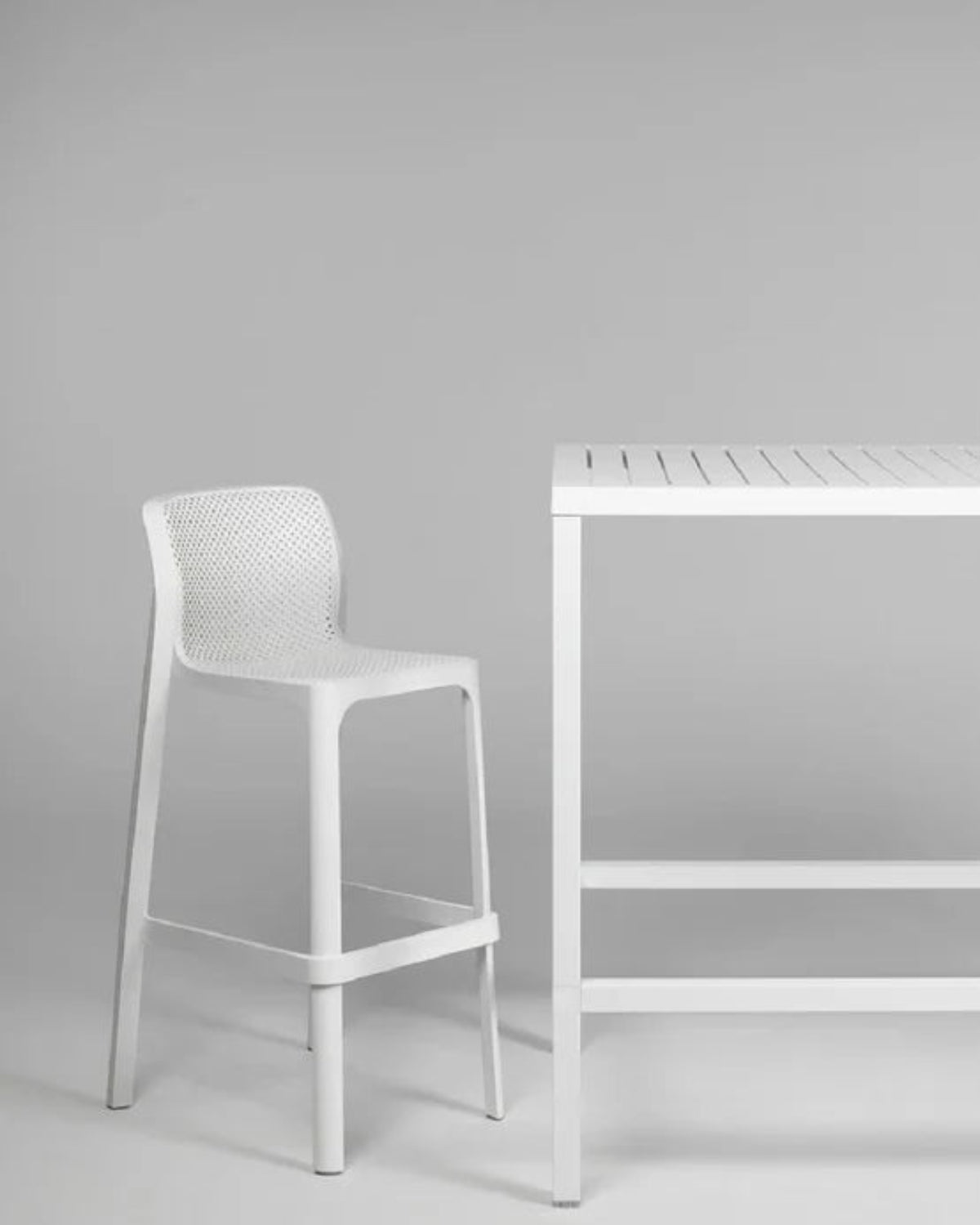 White bar stool and table against a gray background