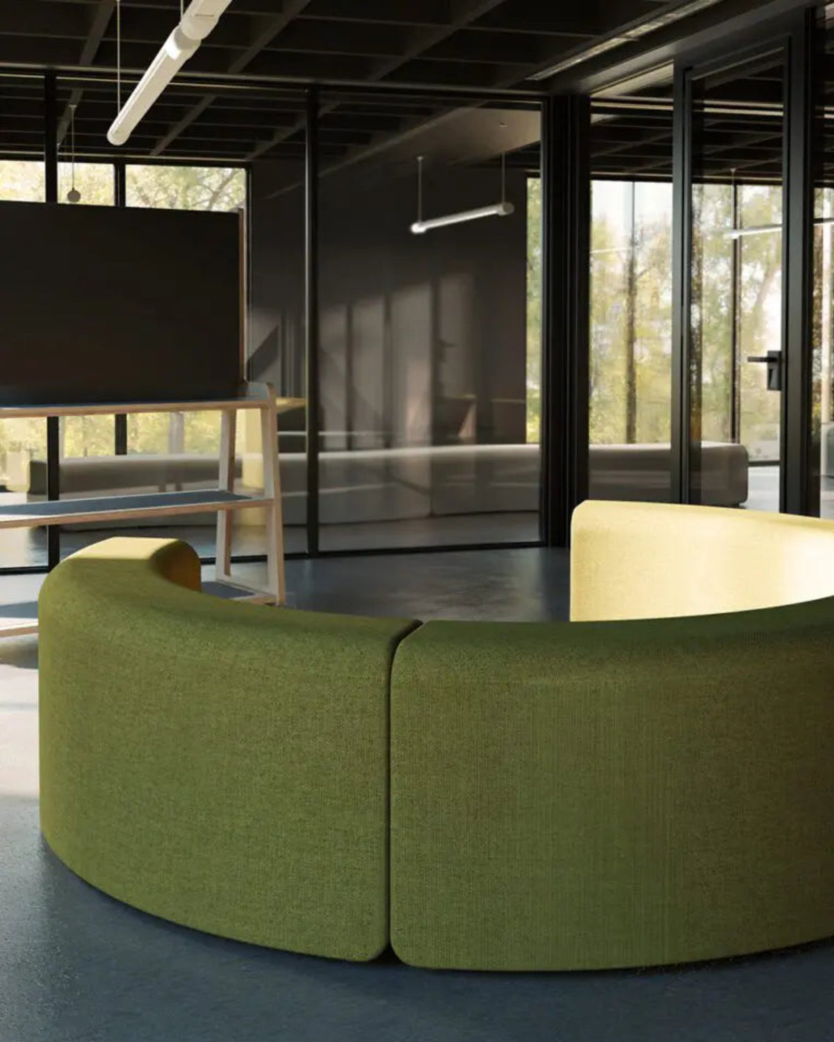 A curved modular upholstered sofa in olive green fabric, shown in a modern office interior with large glass walls and dark ceiling panels.