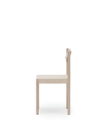 A minimalist light wood dining chair shown from the side against a solid white background.