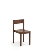 A minimalist wooden dining chair with a square seat and backrest, shown from a three-quarter angle on a clean white background.