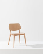 A light natural wood dining chair with a curved backrest and tapered legs, positioned on a white platform against a clean white background.