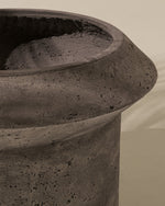 Close-up of a textured stone pot against a beige background