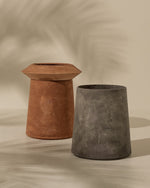 Two rustic planters, one terracotta and one concrete, on a beige background