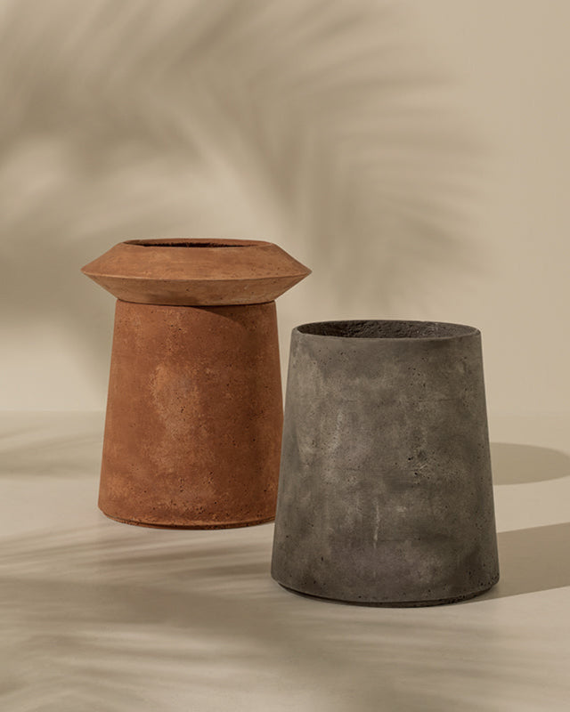 Two rustic planters, one terracotta and one concrete, on a beige background