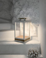 Carre Table Lamp in pickled tea textured matt warmwhite and sitting pn a painted white step of a staircase.