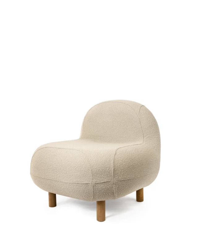 A modern low-profile accent chair upholstered in a textured cream bouclé fabric, featuring a rounded organic silhouette and short wooden legs, shown against a plain white background.