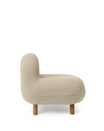 A modern low-profile accent chair upholstered in a textured cream bouclé fabric with tapered natural wood legs, shown from a side profile on a white background.