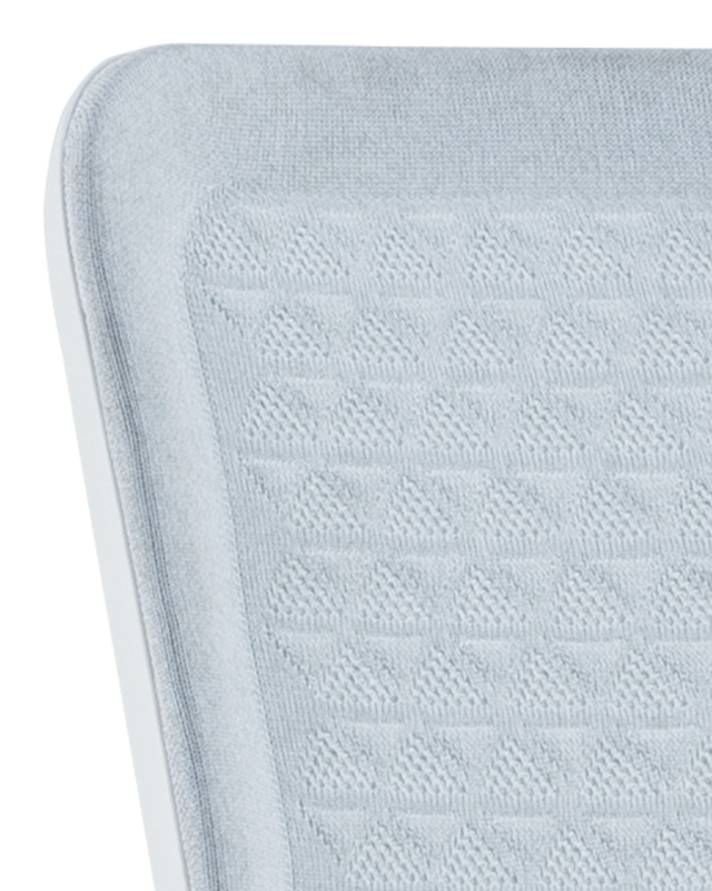 Close-up of a textured light blue cushion with a diamond pattern on a white background