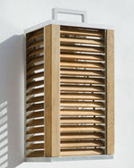 Ginger Wall Lamp hanging from a white wall, outdoors.