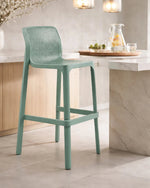 Green bar stool in a kitchen setting with a neutral color palette