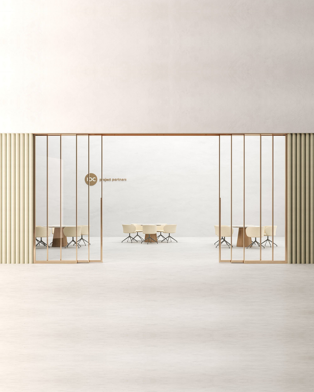 A minimalist interior design scene showing a large open glass partition or door with thin vertical metal bars in a warm gold/bronze tone, flanked by striped beige walls, with tables and chairs visible in the room behind.