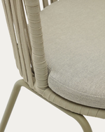 Close-up of a chair with woven backrest and cushioned seat on a light background