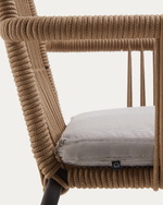 Close-up of a rope-wrapped outdoor chair with a light gray textured cushion on a plain light background.