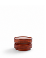 A small amber-brown translucent glass container with a matching lid, featuring a stacked, tiered design, photographed on a clean white background.