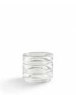 A small clear glass tumbler with a stacked, horizontally ridged design, photographed on a seamless white background.