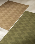 Two geometric-patterned rugs in beige and green on a neutral background