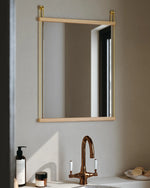 Bathroom with a small Suspended Mirror, sink, and toiletries on a neutral background