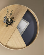 Arc Coffee Table in oiled oak with lid open, revealing hidden storage space lined with smooth nanolaminate.