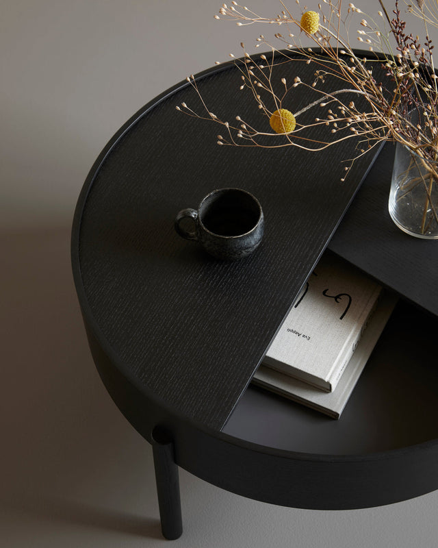 Arc Coffee Table in black with lid open showing hidden storage lined with smooth nanolaminate and dark grey bottom.