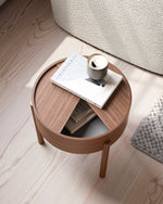 Arc Side Table in walnut with lid open showing hidden storage lined with smooth nanolaminate, three-legged design.