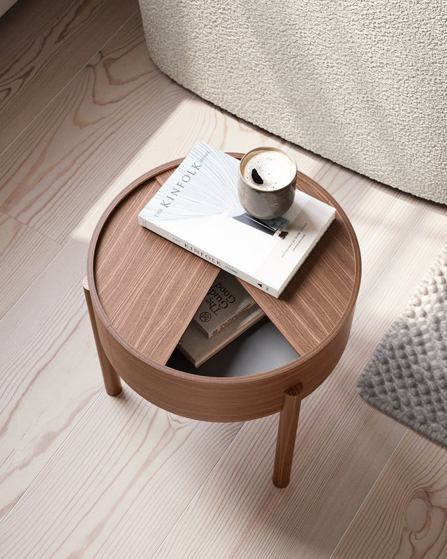 Arc Side Table in walnut with lid open showing hidden storage lined with smooth nanolaminate, three-legged design.