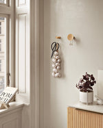 Detail of solid oak wood grain and satin brass metal of large Around wall hanger.