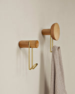 Close-up showing satin brass hook and concave oak back of Around wall hanger.
