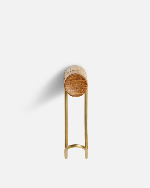 Detail of solid oak wood grain and satin brass metal of small Around wall hanger.