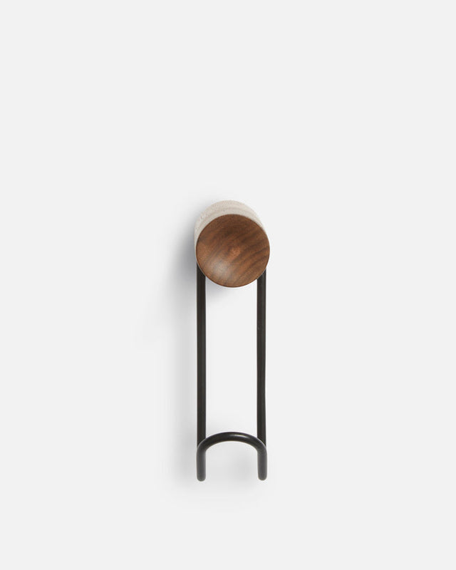 Detail of solid walnut wood grain and black metal of small Around wall hanger.