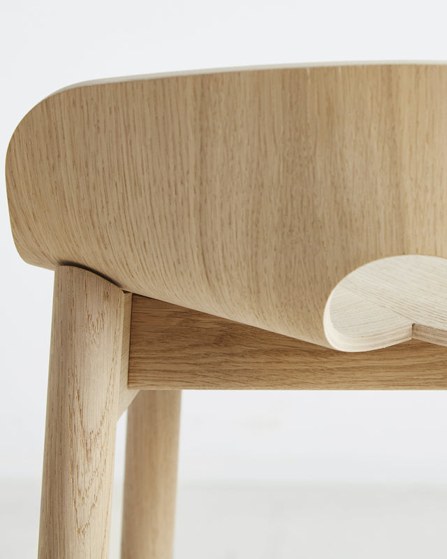 Close-up of the solid oak legs of the Mono Bar Stool with black metal footrest