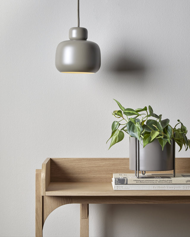 Pidestall Planter (Small Taupe) showcased with leafy greens in a Scandinavian-inspired room, highlighting clean lines and natural textures.