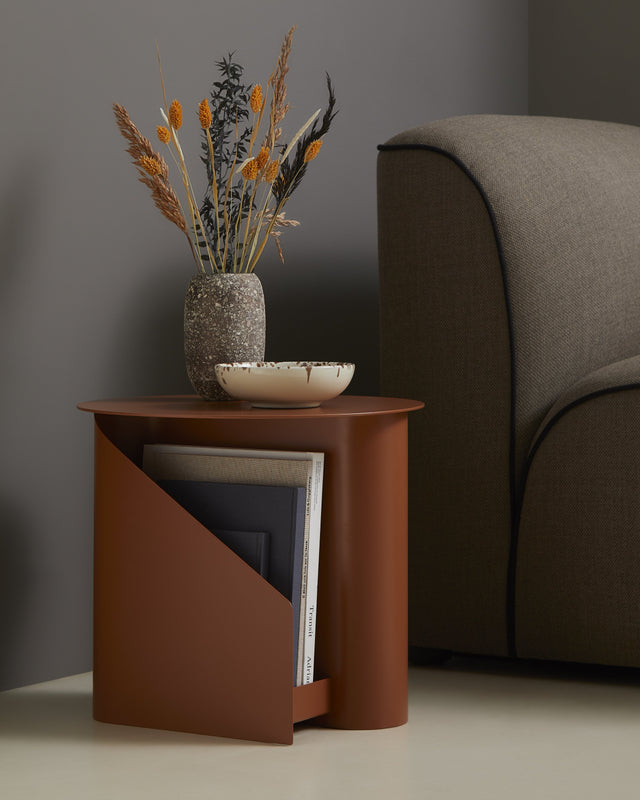 Side view of Sentrum Side Table showing its S-shaped frame and two open magazine slots.
