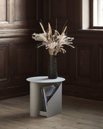 Close-up of painted metal surface finish of the Sentrum Side Table in warm grey.